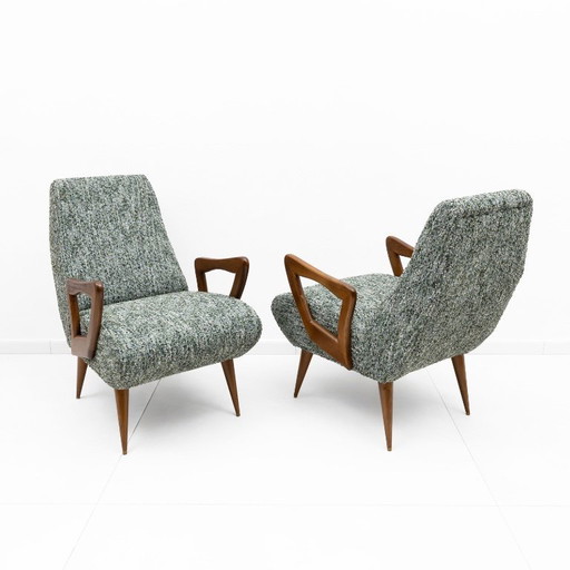 Een paar Italiaanse fauteuils in mid-century modern stijl met sculpturale houten armleuningen.