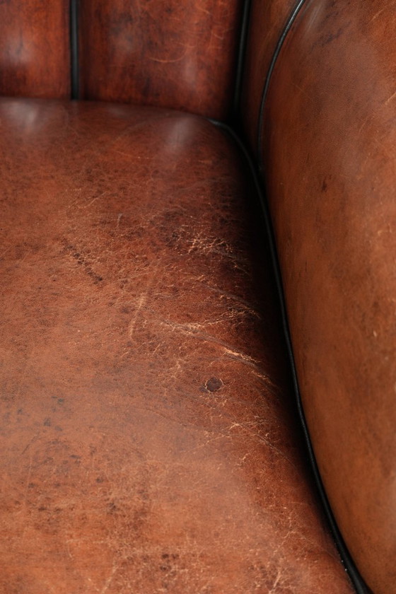 Fauteuil unique en peau de mouton aux couleurs chaudes et profondes, orné d'un passepoil noir. – Leather (photo 9 of 14)