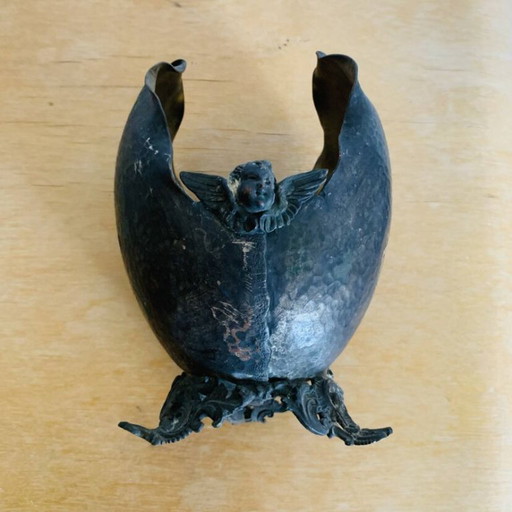 Antieke decoratieve schaal van gehamerd metaal, versierd met putto's.