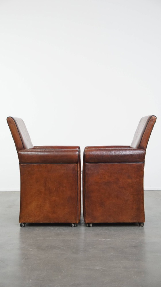 Image 1 of 6 x Vintage sheepskin dining chair with black piping on wheels