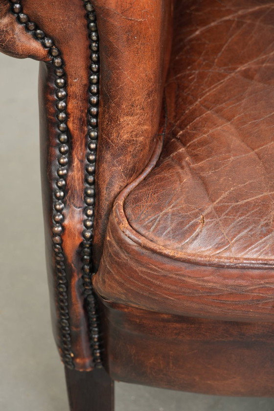 Ruime vintage schapenleren oorfauteuil in een diepe bruine kleur afgewerkt met siernagels – Leather (photo 15 of 17)