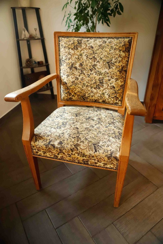Image 1 of Vintage salonfauteuil met bloemenpatroon op de bekleding en sierlijke armleuningen.