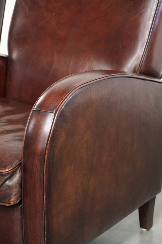 Image 1 of 2x dunkel cognacfarbene Schaffellsessel mit abgerundeten Formen und elegantem Design