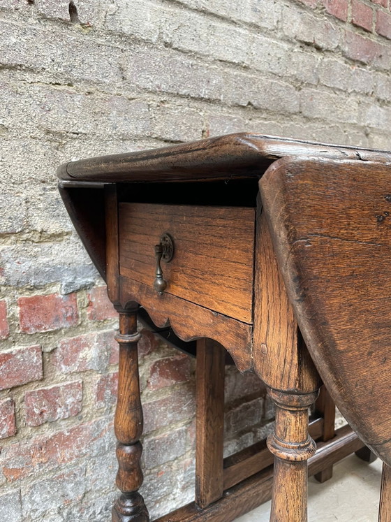 Image 1 of Tavolo antico in rovere con gambe a ribalta e cassetto