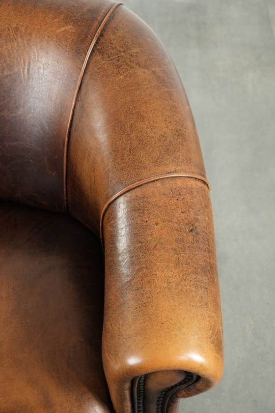 Image 1 of Karaktervolle en comfortabele clubfauteuil gemaakt van schapenleer met een vast zitkussen en uitmuntende kleuren