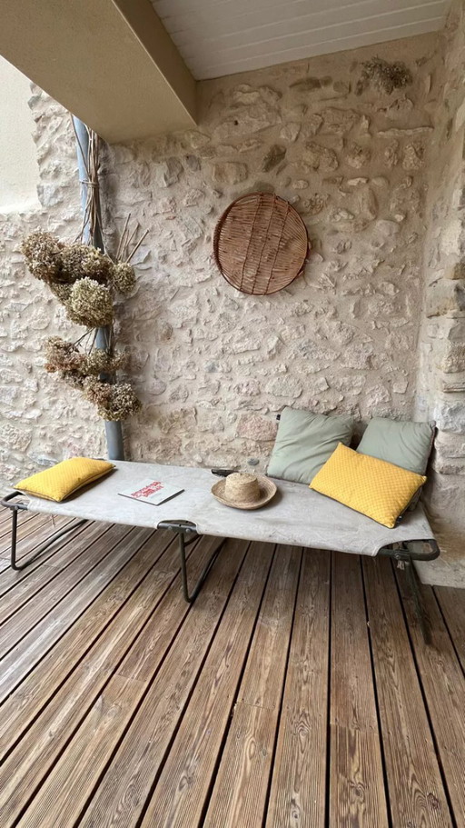 Vintage opklapbaar militair veldbed van kaki groen canvas en metaal.