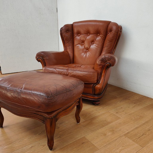 Vintage cognac kleurige lederen fauteuil, oorfauteuil. Stoel met hocker leer.