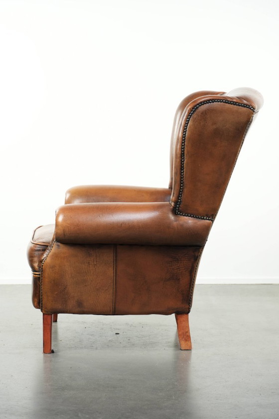 Image 1 of Comfortabele oorfauteuil gemaakt van schapenleer afgewerkt met siernagels en een karaktervolle uitstraling in Engelse stijl