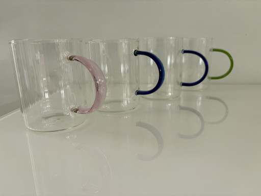 Set of four modern design mugs with colored handles
