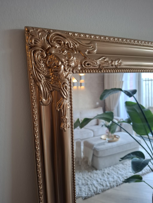 Lujoso espejo grande de aspecto antiguo de color dorado.