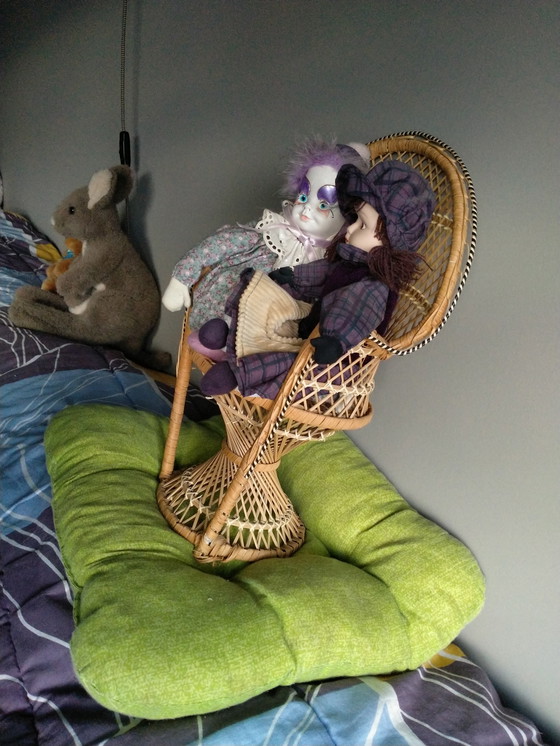 Image 1 of Deux véritables poupées en porcelaine sur une chaise en osier originale