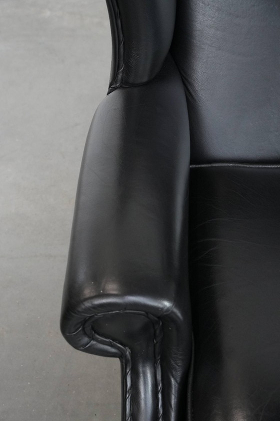 Image 1 of Smooth black cowhide Chesterfield wingback armchair in English style with color-matched piping