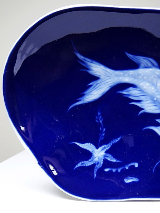 Image 1 of Plato pequeño de porcelana de Limoges con esmalte azul y decoración de peces al estilo japonés.