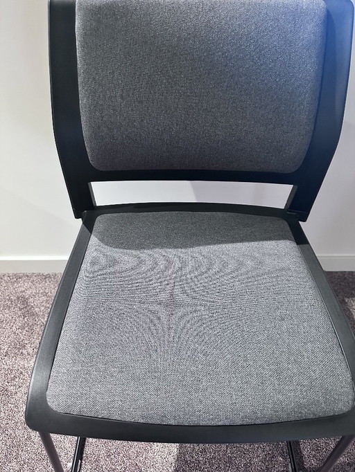 Schwarzer Stuhl mit grauem Sitzkissen