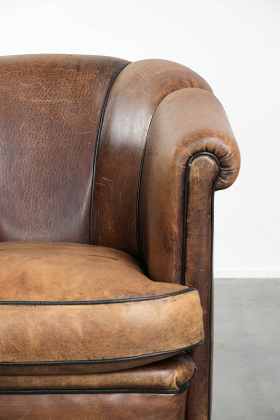 Image 1 of Leuke vintage schapenleren clubfauteuil in Engelse stijl met zwarte biezen