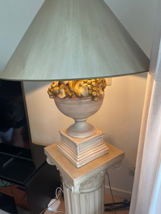 lampe en pierre avec décoration de fruits sur la base et le socle