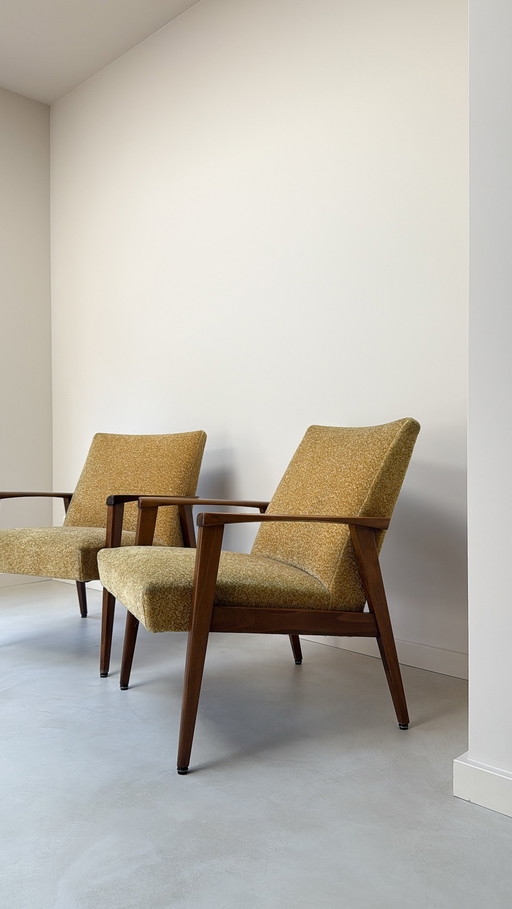 Two vintage teak wood armchairs with fabric upholstery