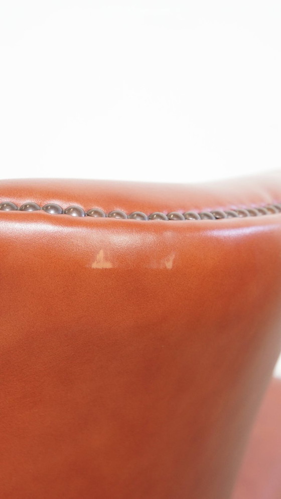 Image 1 of Elegante en comfortabele gladde Engelse rundleren chesterfield oorfauteuil met sierlijke pootjes