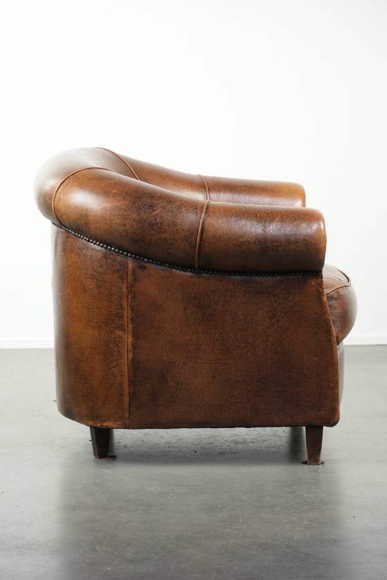 Image 1 of Karaktervolle en comfortabele clubfauteuil gemaakt van schapenleer met een vast zitkussen en uitmuntende kleuren
