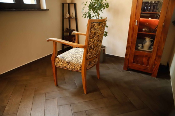 Image 1 of Vintage salonfauteuil met bloemenpatroon op de bekleding en sierlijke armleuningen.