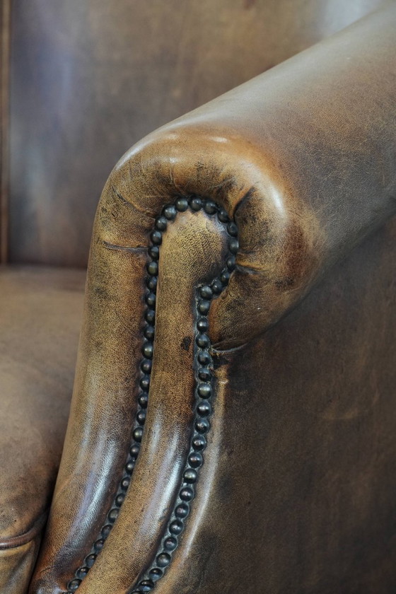 Image 1 of Clubfauteuil gemaakt van schapenleer afgewerkt met siernagels