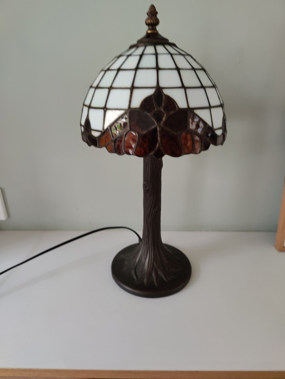 Image 1 of Lámpara de mesa estilo Tiffany con pantalla de vidrieras y base de bronce.