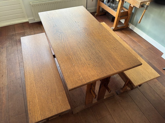 Image 1 of Tavolo da pranzo in legno con due panche abbinate.