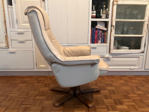 Poltrona girevole vintage in pelle color crema, ideale per rilassarsi negli anni Settanta.