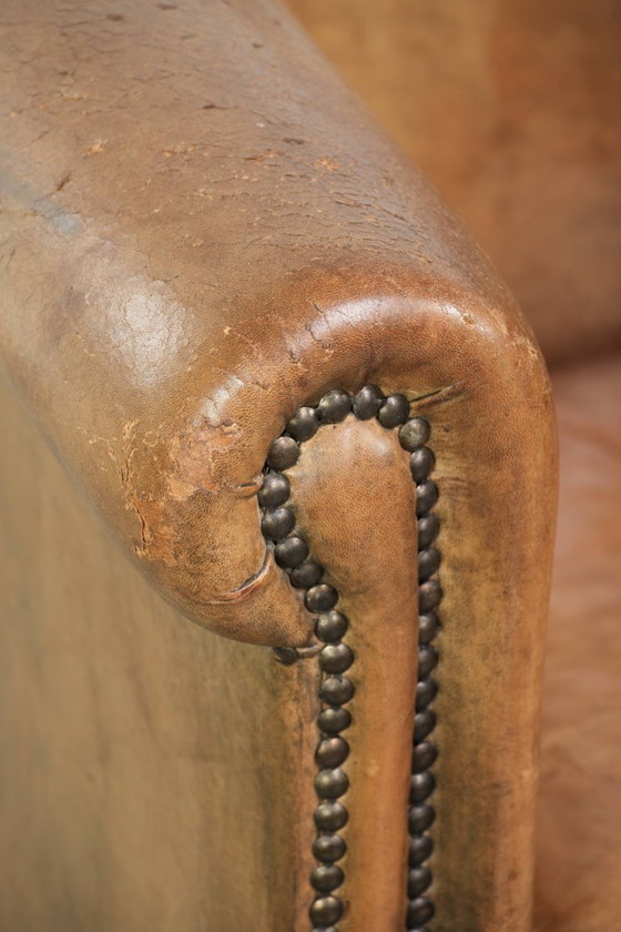 Image 1 of Vintage sheepskin club armchair with beautiful colors and finished with decorative nails.