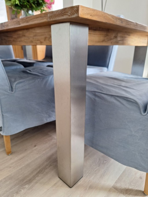 Robust dining table with teak top and stainless steel legs