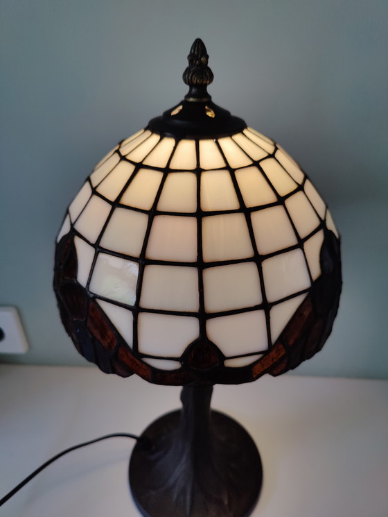 Image 1 of Lámpara de mesa estilo Tiffany con pantalla de vidrieras y base de bronce.