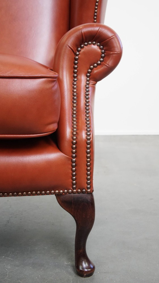 Image 1 of Elegante en comfortabele gladde Engelse rundleren chesterfield oorfauteuil met sierlijke pootjes