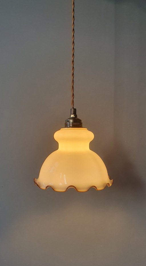 Piccola lampada a sospensione vintage in vetro con bordo decorativo color marrone.