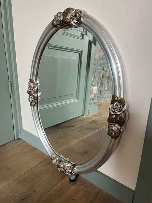 Ovale barokspiegel met zilverkleurige lijst/gouden bloemen