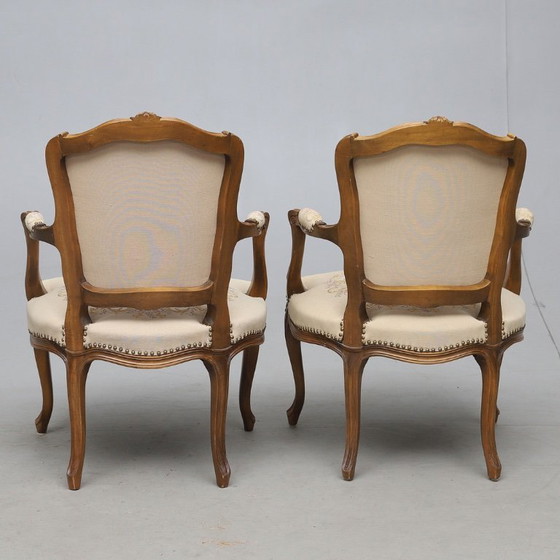 Image 1 of Een paar antieke houten fauteuils in Lodewijk XV-stijl met rococo-uitvoering, daterend uit 1950-1960.