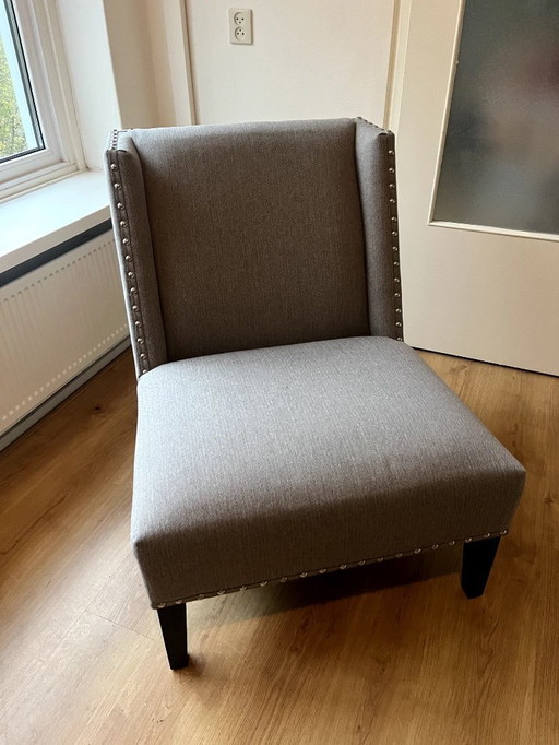 La silla Columbia de Eichholtz, un sillón de diseño con detalles de clavos decorativos.