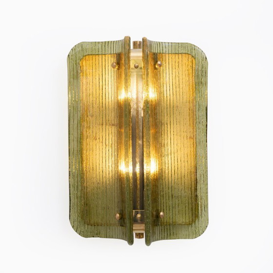 Image 1 of Een paar gebogen, geribbelde wandlampen van Murano-glas en messing.