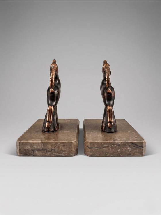 Image 1 of Serre-livres Art Déco en régule patiné – paire animalière stylisée – socles en marbre taupe – années 1930