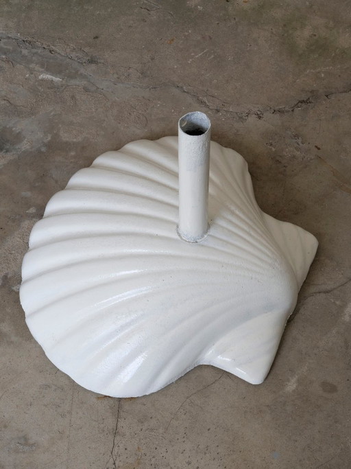 Sombrilla de jardín vintage con base de hierro fundido y diseño de concha marina de Fermob.