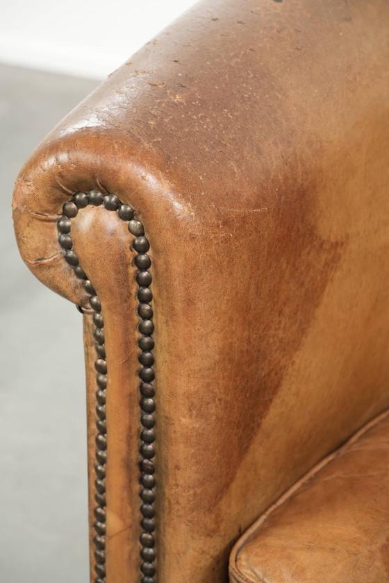 Image 1 of Vintage sheepskin club armchair with beautiful colors and finished with decorative nails.