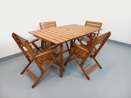 Vintage garden furniture consisting of a table with extensions and 4 wooden armchairs from the 60s