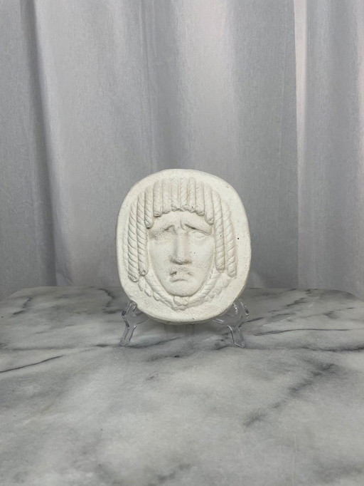 Antique mask-style low-relief face