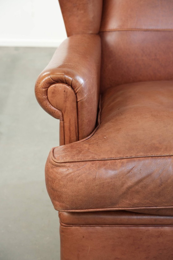 Image 1 of Poltrona a orecchioni color cognac chiaro, rivestita in pelle bovina, dal caratteristico look inglese.