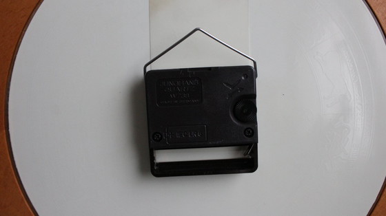 Image 1 of Horloge murale vintage Junghans avec boîtier en bois et signe du zodiaque sur un cadran en verre.