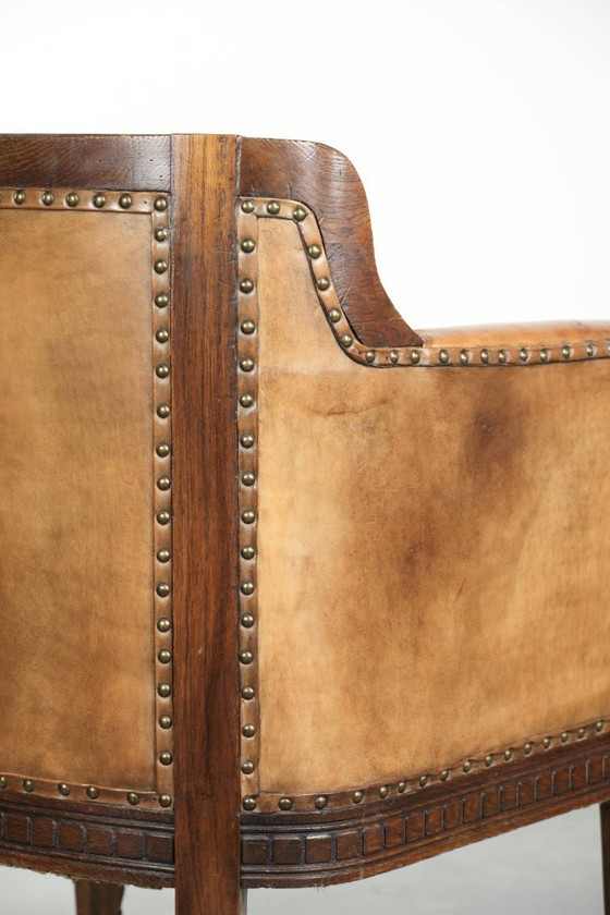 Image 1 of Antique armchair of sheepskin and wood with decorative nails and beautiful woodwork