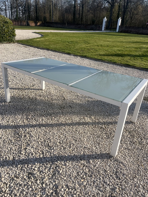 Bellissimo tavolo da giardino di design con piano in vetro satinato.