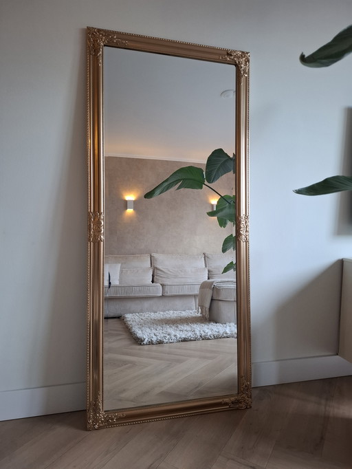 Lujoso espejo grande de aspecto antiguo de color dorado.