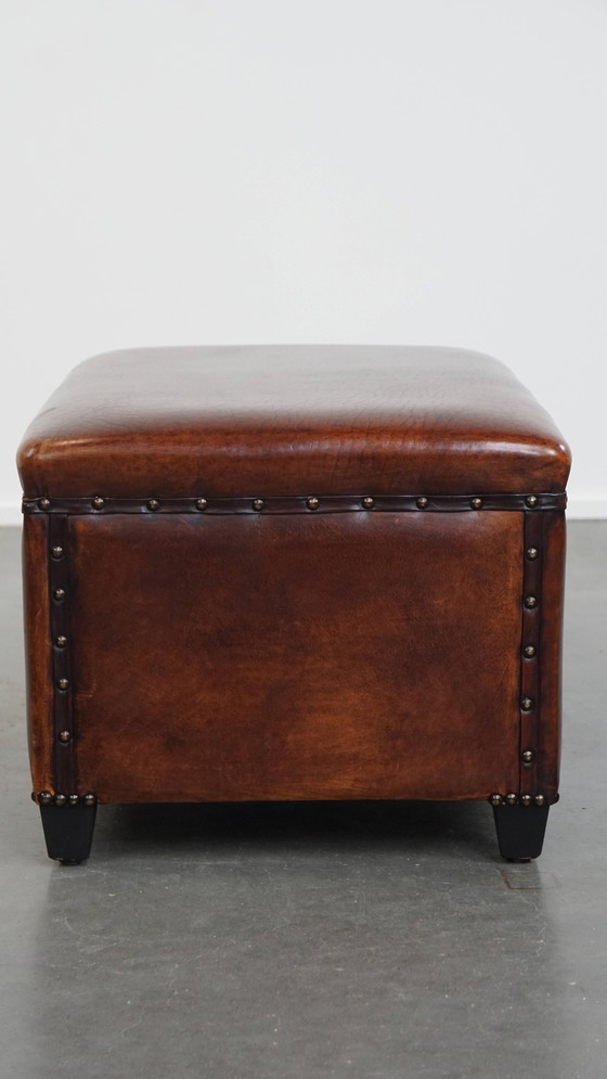 Image 1 of Cognac-kleurige schapenleren hocker met siernagels
