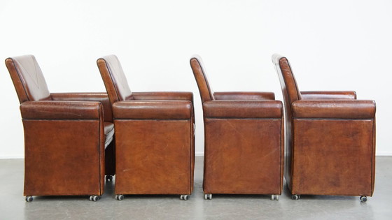 Image 1 of 4 x Vintage schapenleren eetkamerstoel met zwarte biezen op wieltjes