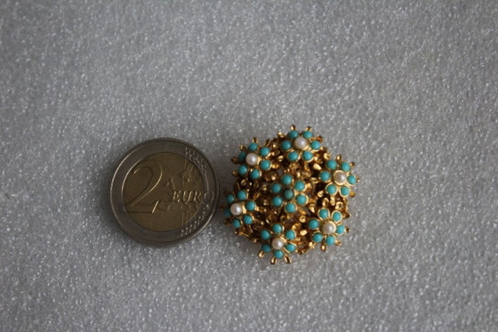 Image 1 of Ronde vintage broche, goudkleurig metaal met kleine groene en witte parels.